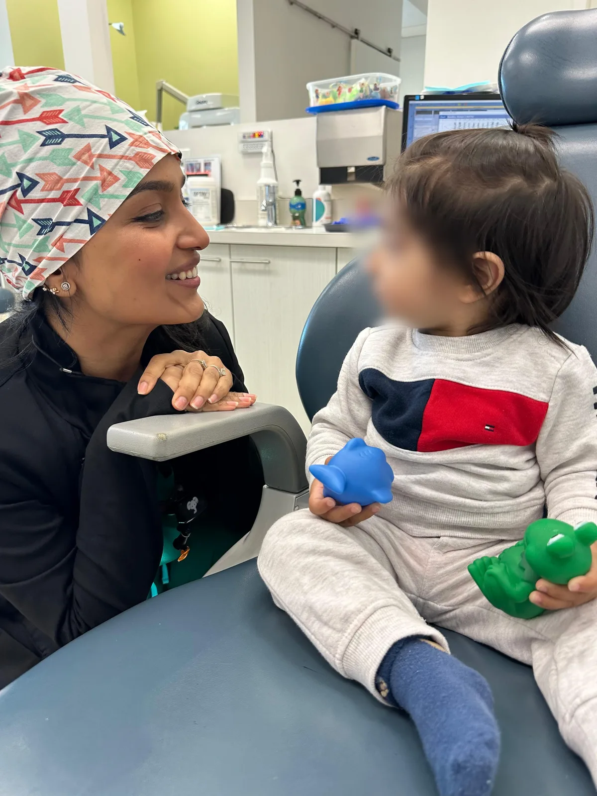 Dr. Nidhi chatting with a toddler in the dental chair