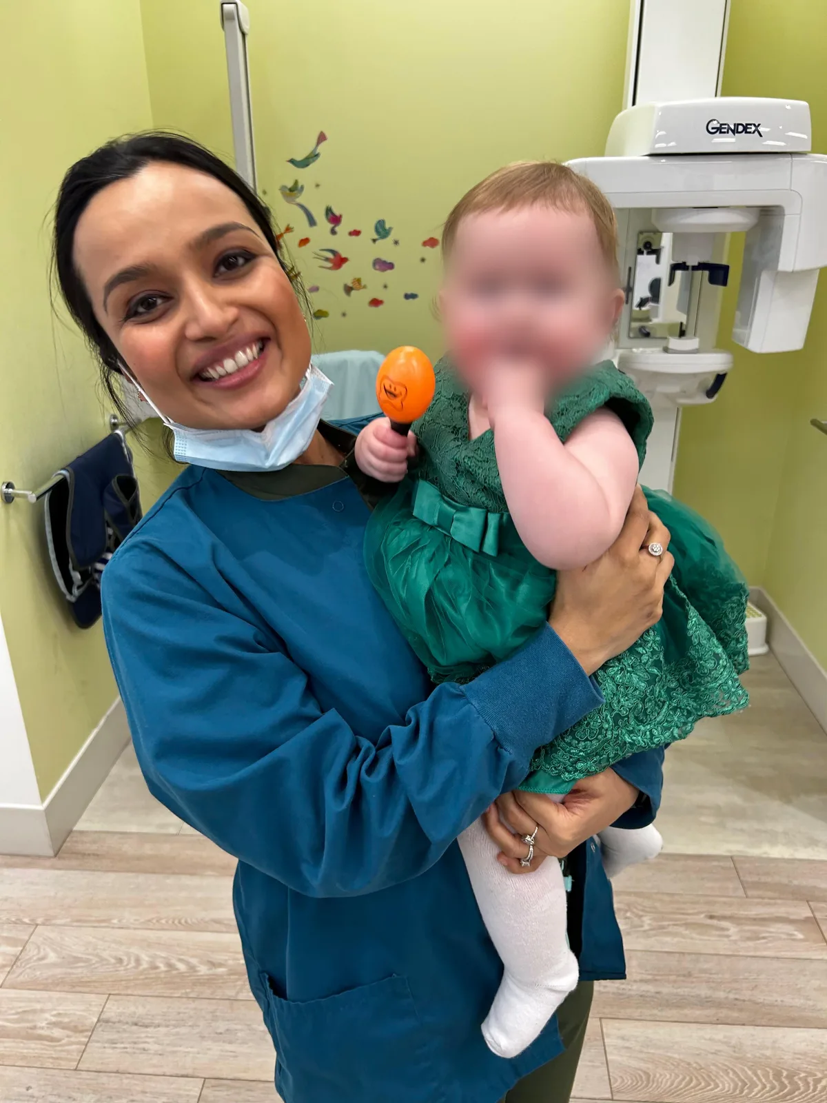 Dr. Nidhi holding a baby patient at the clinic